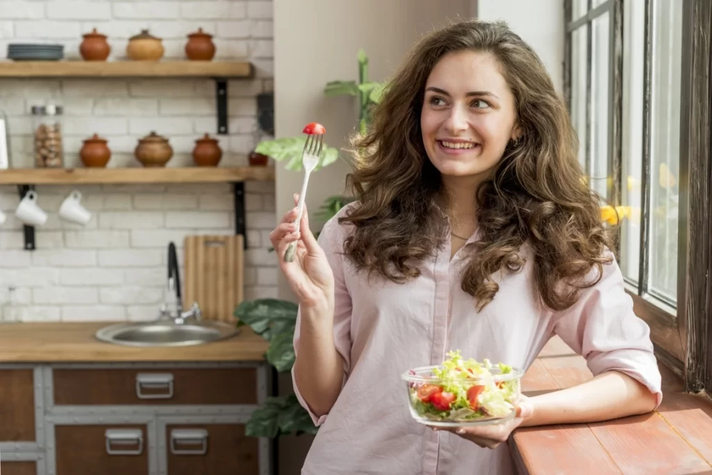 Brunette women with curly hair eating salad